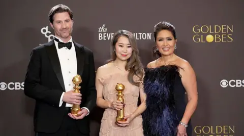 Getty Images Chris Appelhans, Maggie Kang and Michelle Wong, winners of the Best Motion Picture - Animated Award for "KPop Demon Hunters," pose in the press room at the 83rd Annual Golden Globe Awards at The Beverly Hilton on January 11, 2026 in Beverly Hills, California.