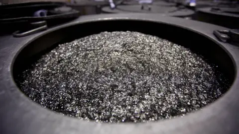 Bloomberg via Getty Images Neodymium-containing boron magnets sit in a barrel prior to being crushed into powder in a factory in China