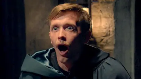 Stephen in his traitor's cloak with an open-mouthed, wide-eyed look of amazement