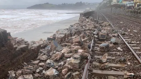 Network Rail Crumbled rocks are seen over a railway line.