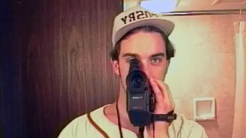 Netflix Robbie Williams films himself in a mirror using a camcorder during the first flush of Take That's fame