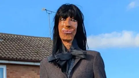 Sharon Kulesa An effigy of Claudia Winkleman sitting on a garden fence.