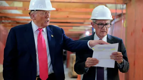 Getty Images US President Donald Trump directs the attention of Federal Reserve Chair Jerome Powell to documents, during a July 2025 tour of the Federal Reserve’s $2.5bn headquarters renovation project 

