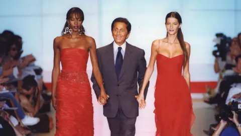 Getty Images Fashion designer Valentino walks the runway with Naomi Campbell and Gisele Bündchen at the end of his 1999/2000 Haute Couture show in Paris, France, in July 1999.