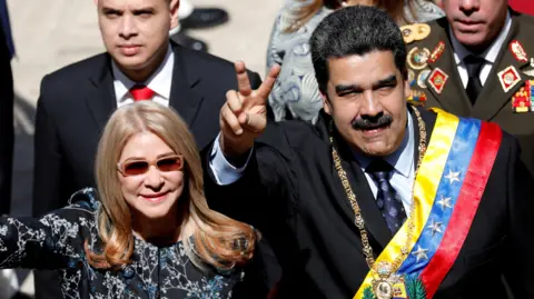Reuters Venezuela's President Nicolas Maduro gestures next to his wife Cilia Flores during his arrival for a special session of the National Constituent Assembly 