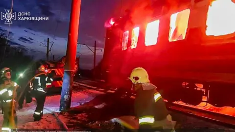 Ukraine's DSNS emergency service/Kharkiv region A photo released by Ukraine's DSNS emergency service show its employees tackle a fire as a carriage of a passenger train burns after a Russian drone attack in Ukraine's north-eastern Kharkiv region. Photo: 27 January 2026